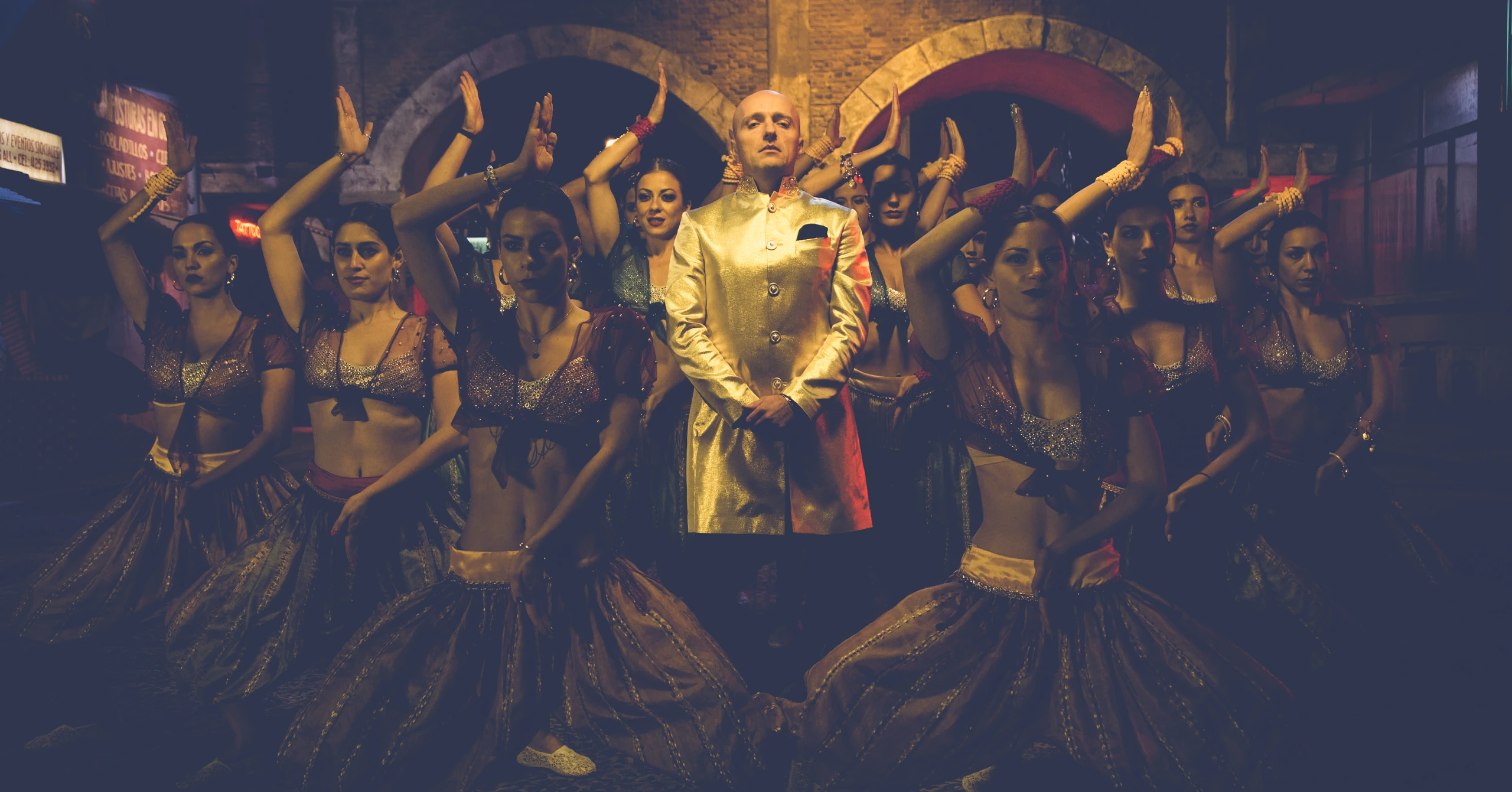 Costi in a gold jacket on a music video set